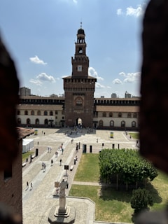 Group of happy travelers exploring a historic castle courtyard during a sunny day