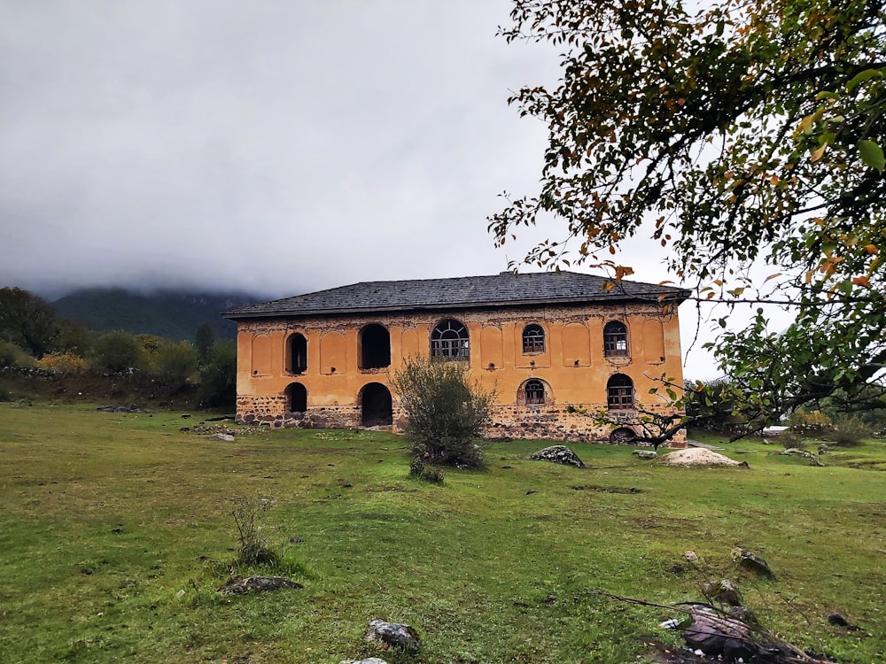 an old building in the middle of a field