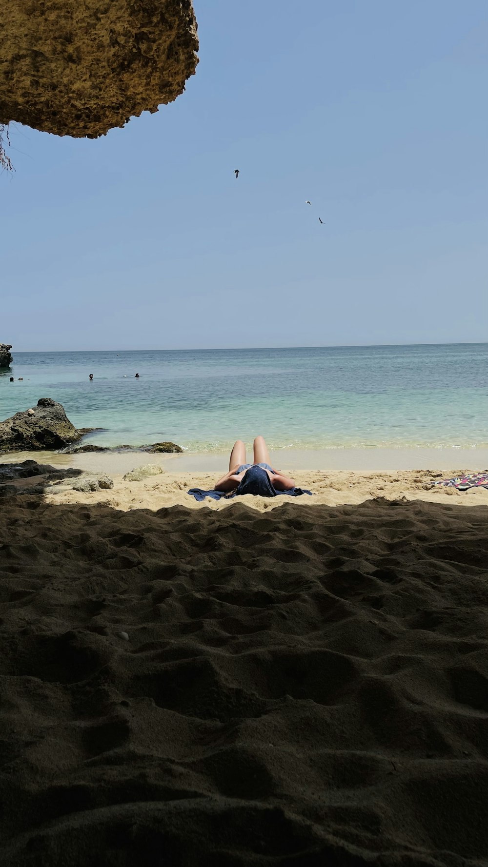 a person laying in the sand on a beach