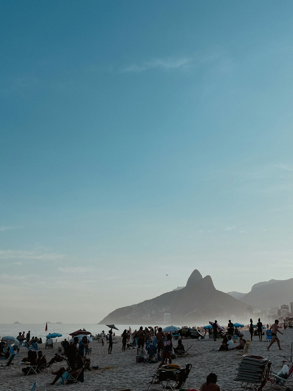 a group of people sitting on top of a sandy beach