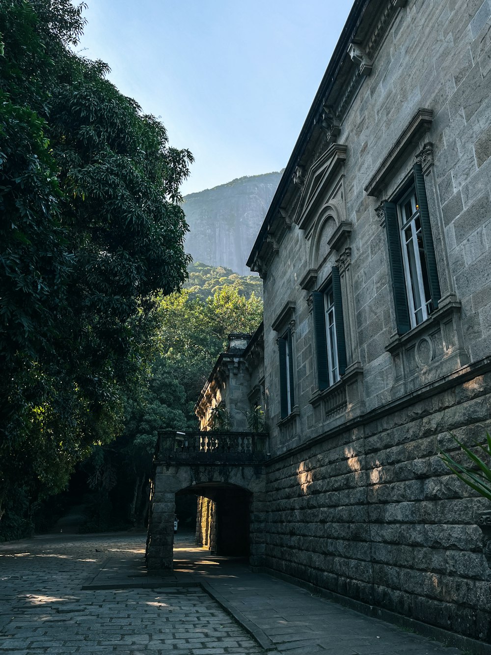 a stone building with green shutters on the windows