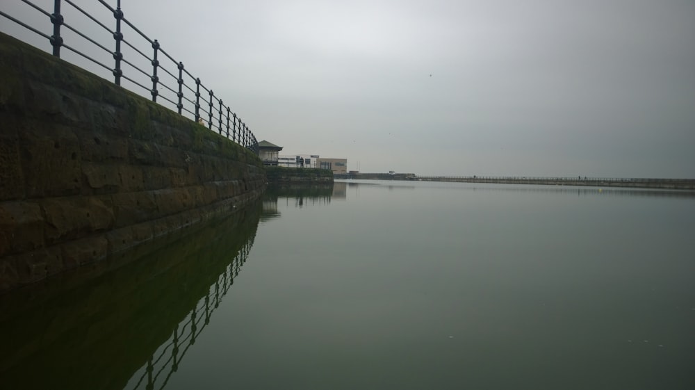 a body of water next to a fenced in area