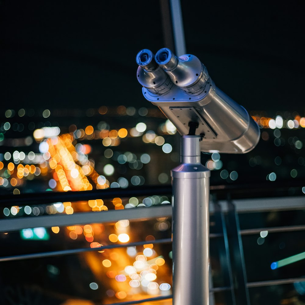 a telescope sitting on top of a metal pole