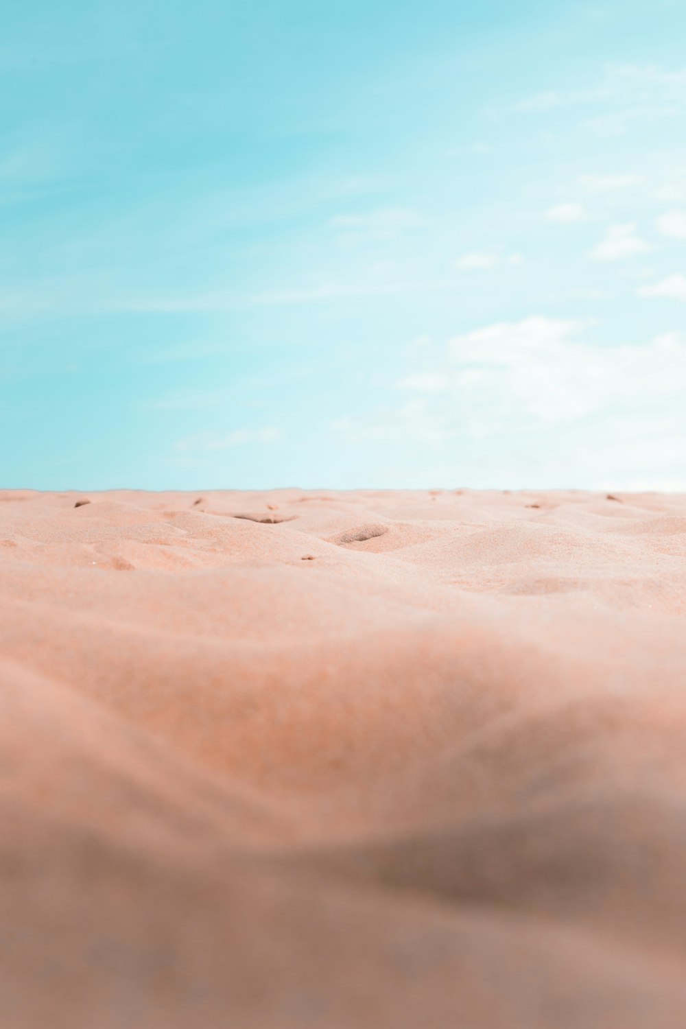 a blurry photo of a sandy area with a blue sky in the background