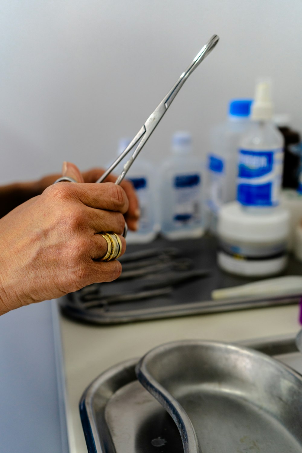 a person holding a pair of scissors over a sink