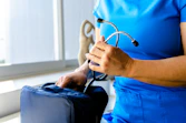 a woman in a blue scrub suit holding a stethoscope