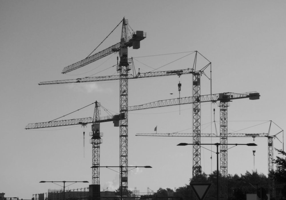 a black and white photo of construction cranes