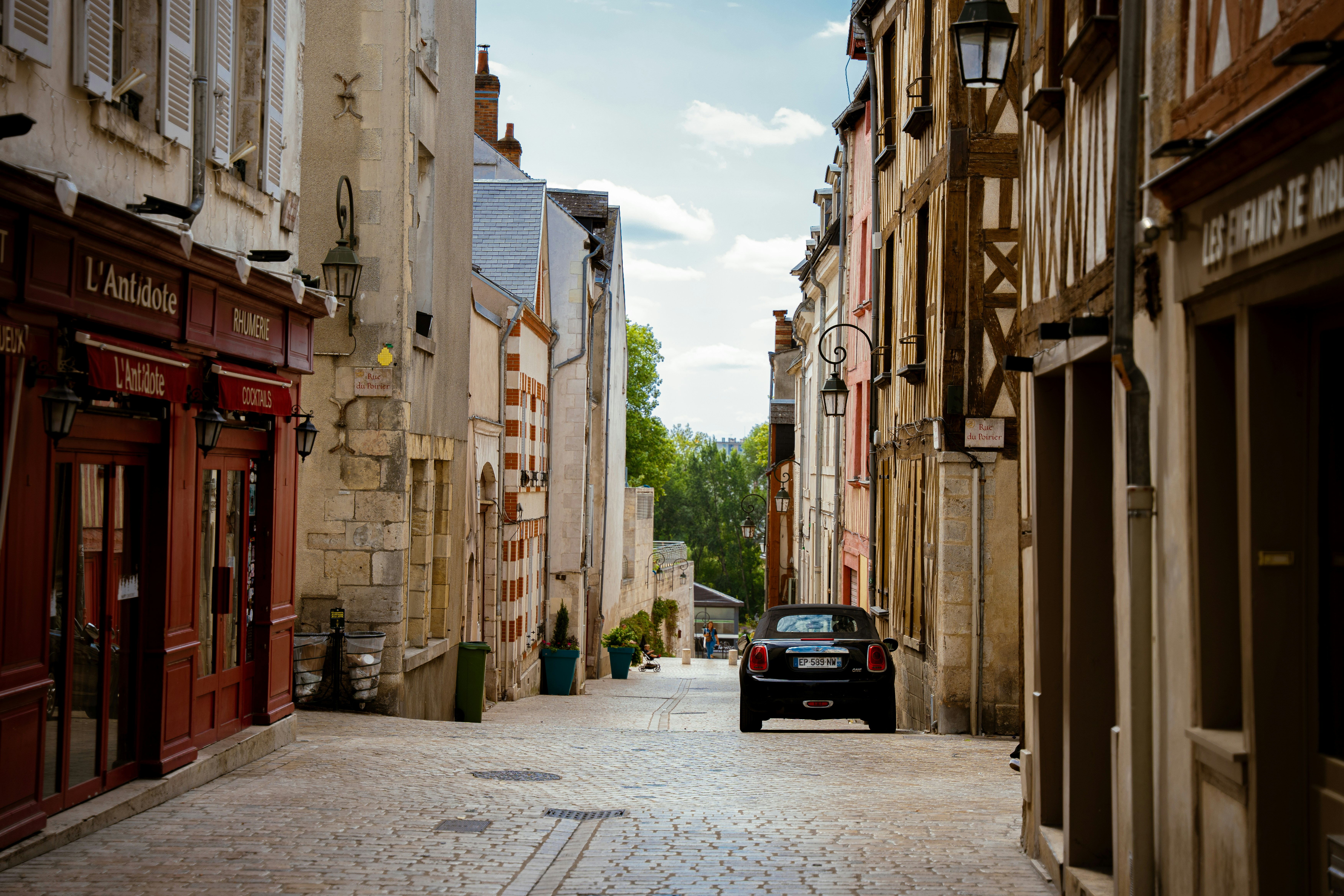 a car is driving down a narrow street