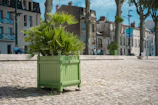 Large urban garden planter with robust mineral matrix and green neon button accent in a dark setting.