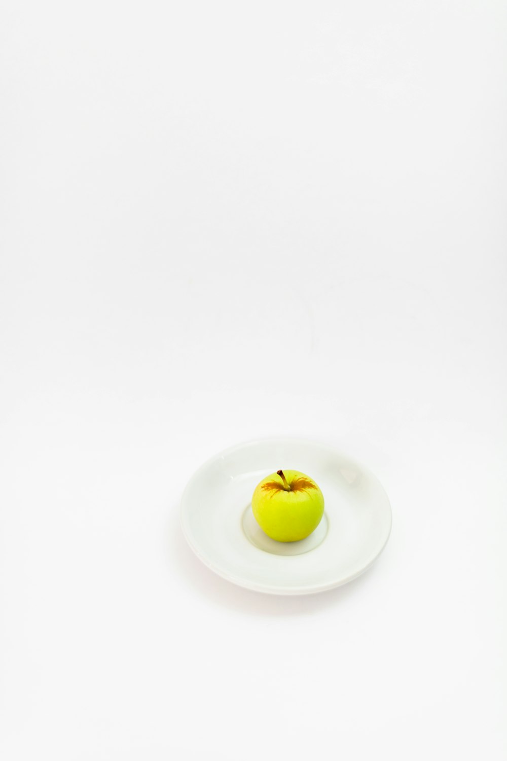 an apple on a plate on a white background