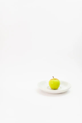 Close-up of vibrant green apple slices arranged on a minimalist white plate