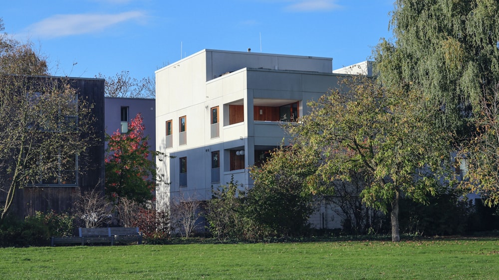 a large white building sitting on top of a lush green field