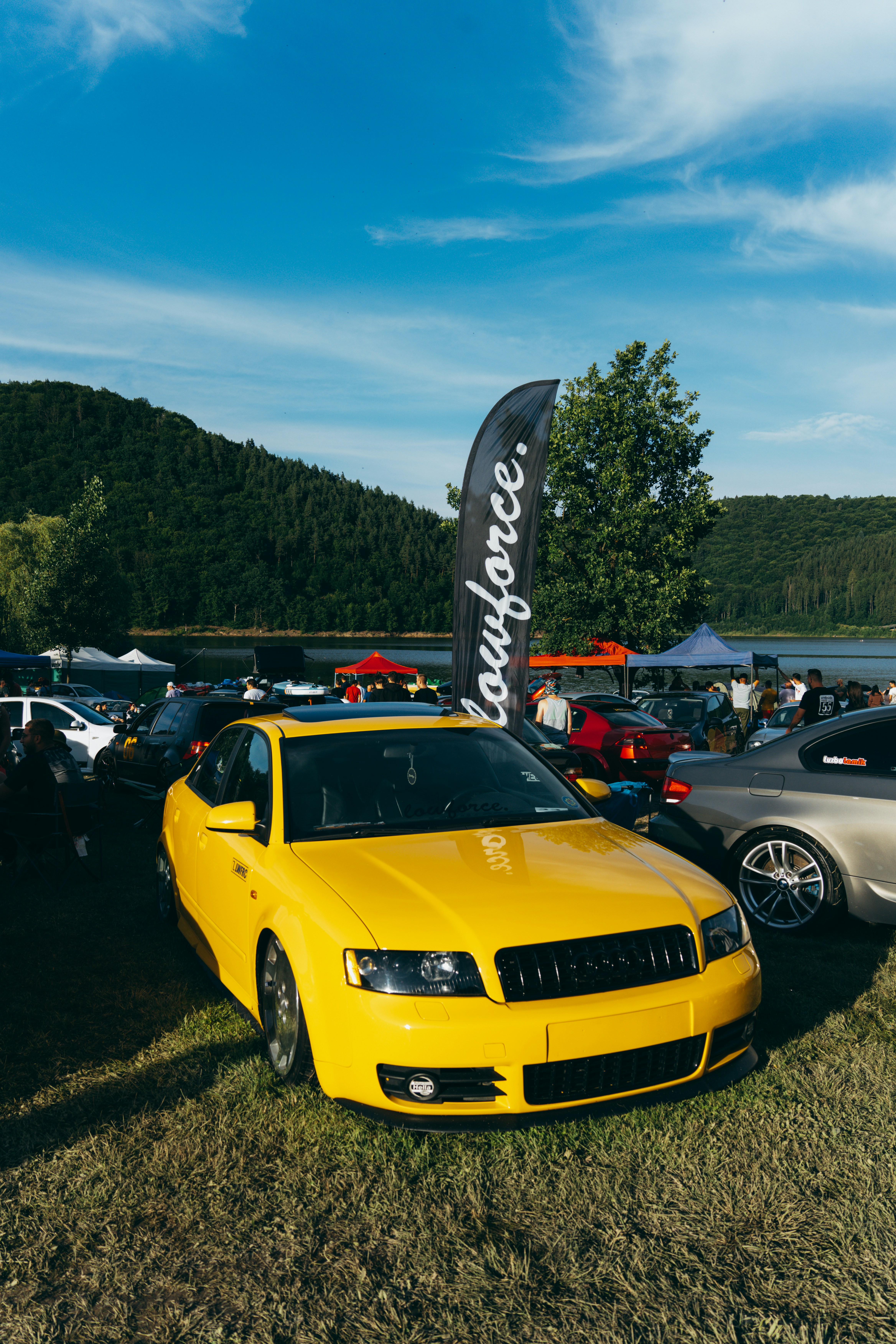 a yellow car parked in a field next to other cars