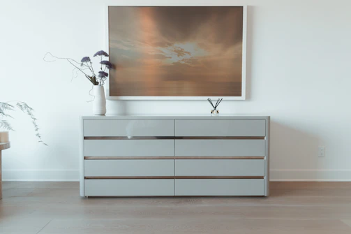 Voltari handyman installing a neat, multi-compartment dresser in a cozy bedroom.