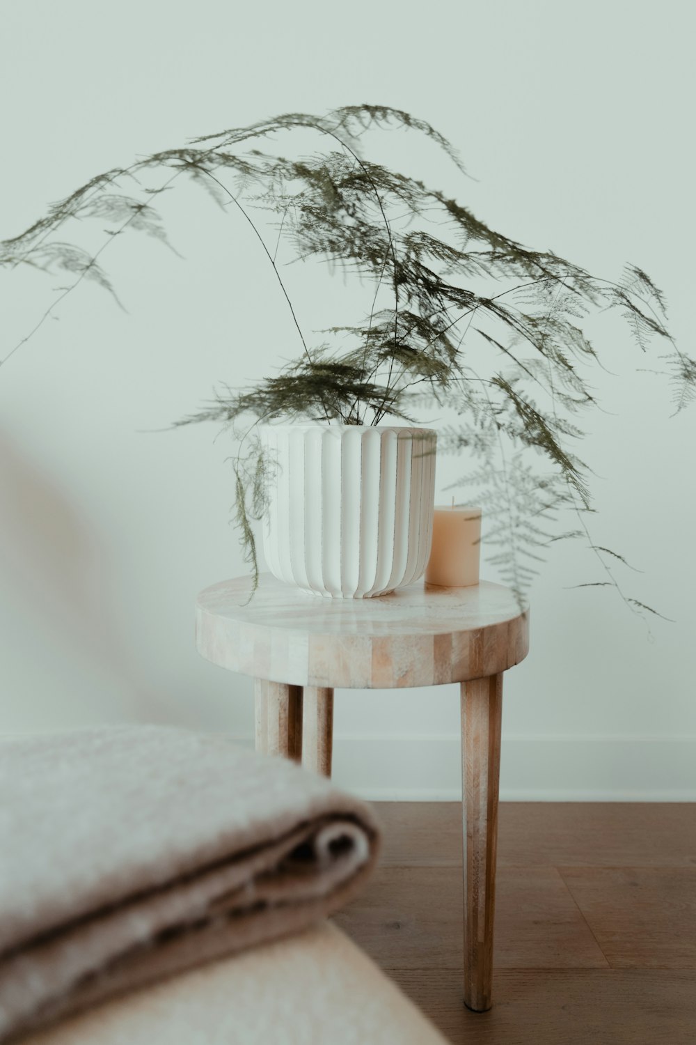 a white vase sitting on top of a wooden table