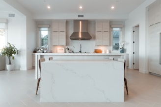 a kitchen with a marble counter top and white cabinets
