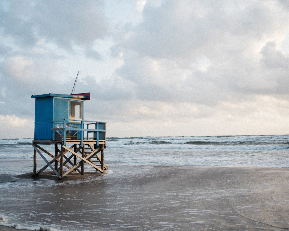 Una torre de salvavidas sentada en la cima de una playa junto al océano