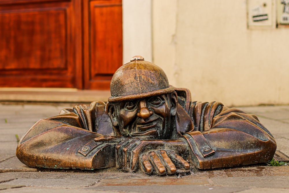 a statue of a man with a helmet on laying on the ground