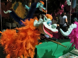 A colorful illustration of a whimsical puppet character in mid-performance.