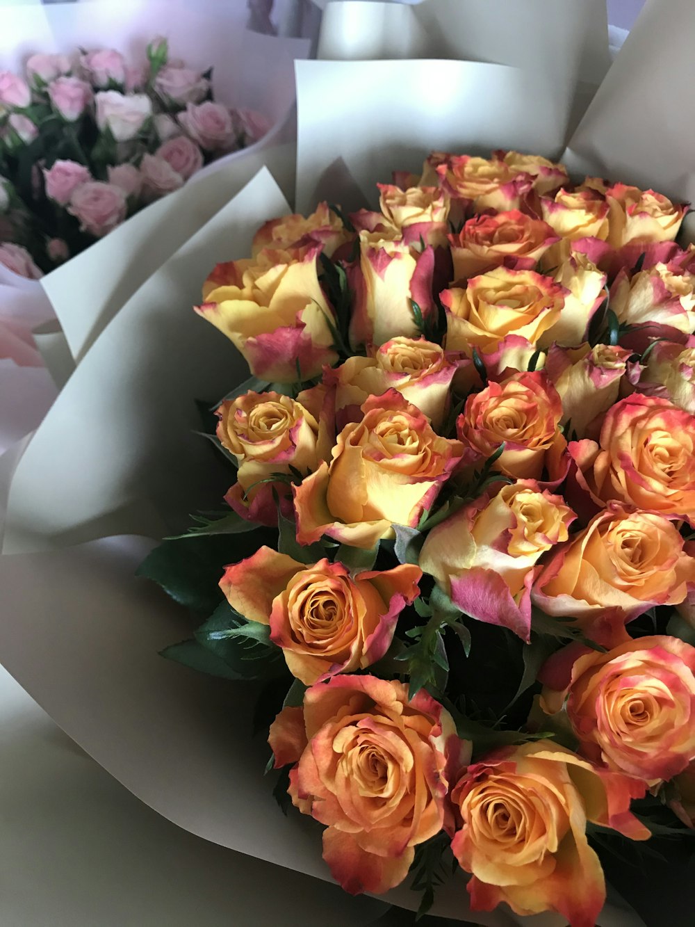 a bouquet of orange and pink roses on a table