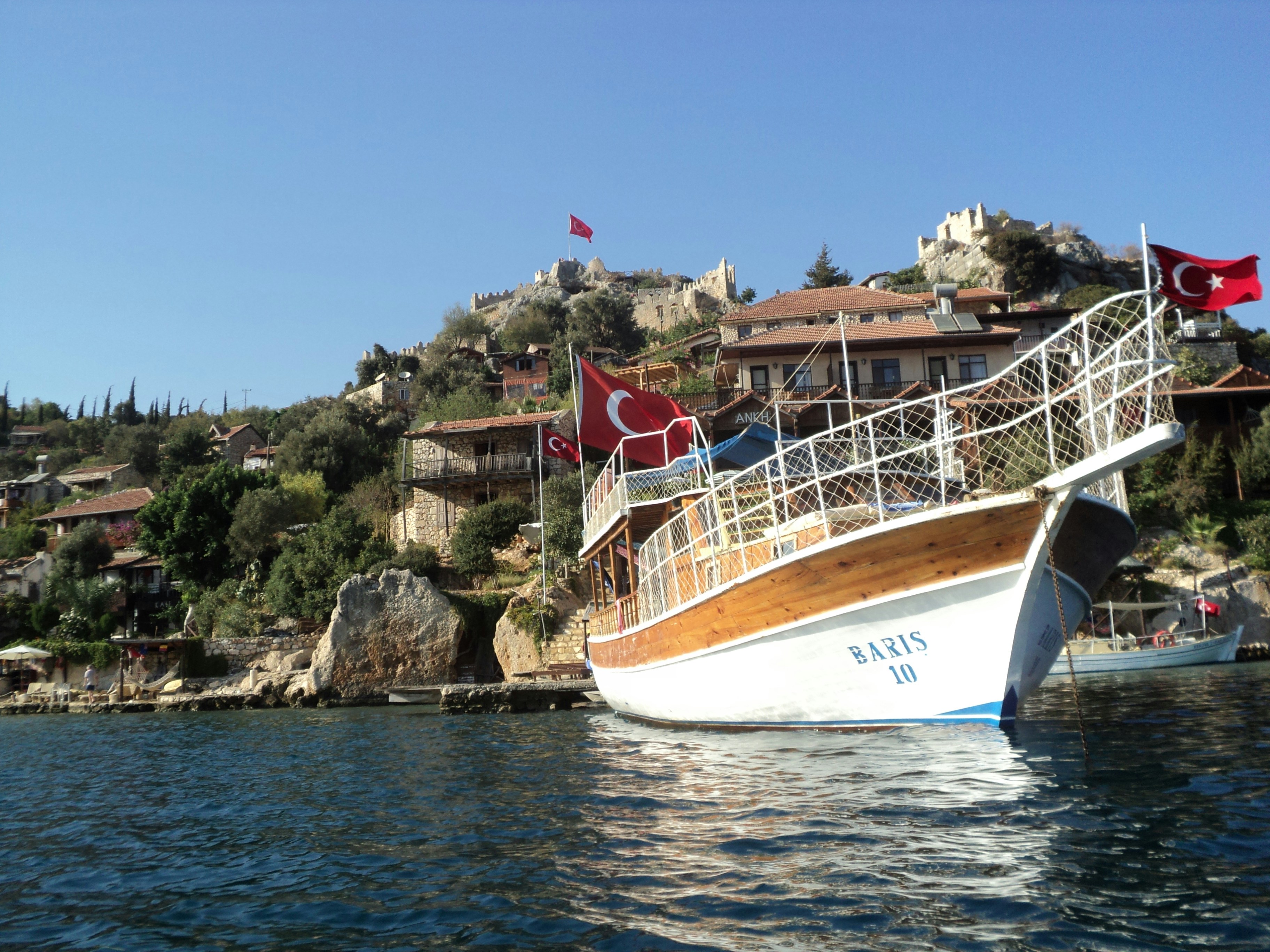 a boat in a body of water next to a hillside