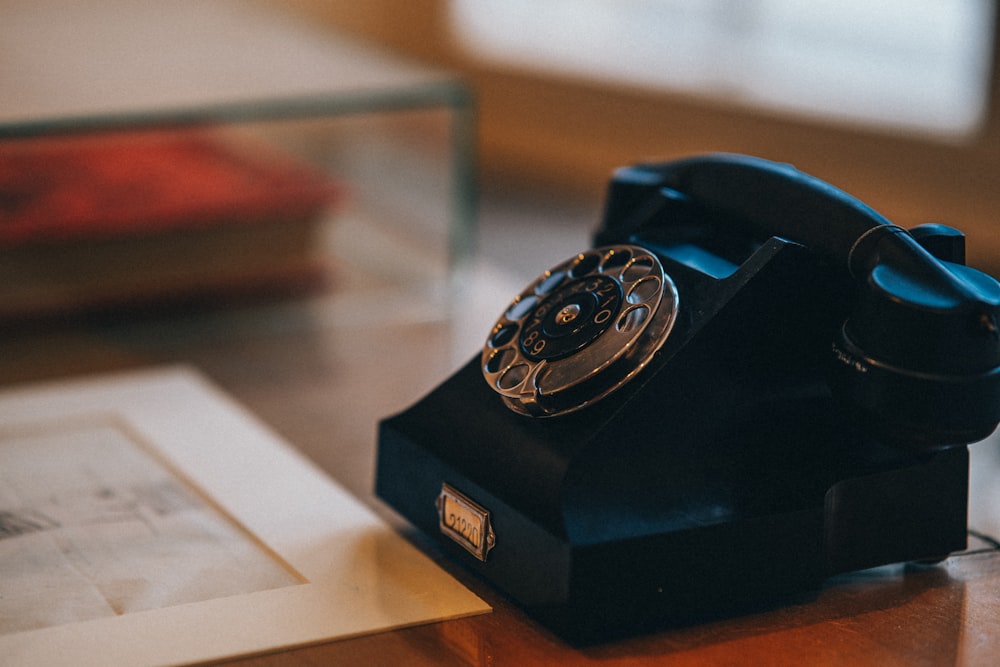an old - fashioned rotary telephone sits on a table