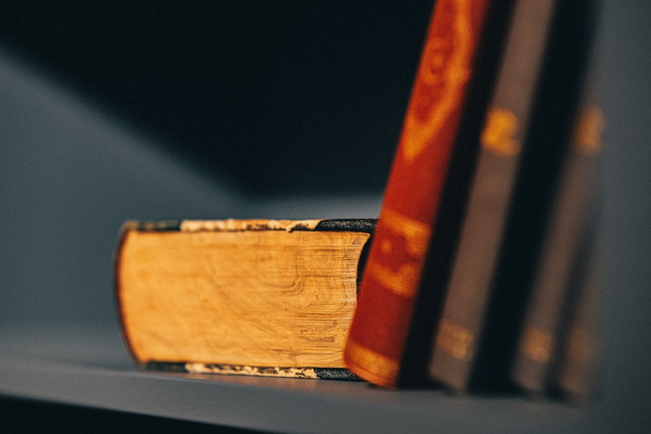 A stack of Indonesian military history books with a vintage soldier helmet on top