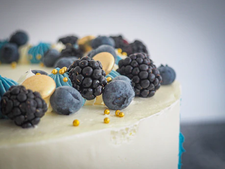 Close-up of a deliciously decorated homemade cake with vibrant frosting and fresh berries.