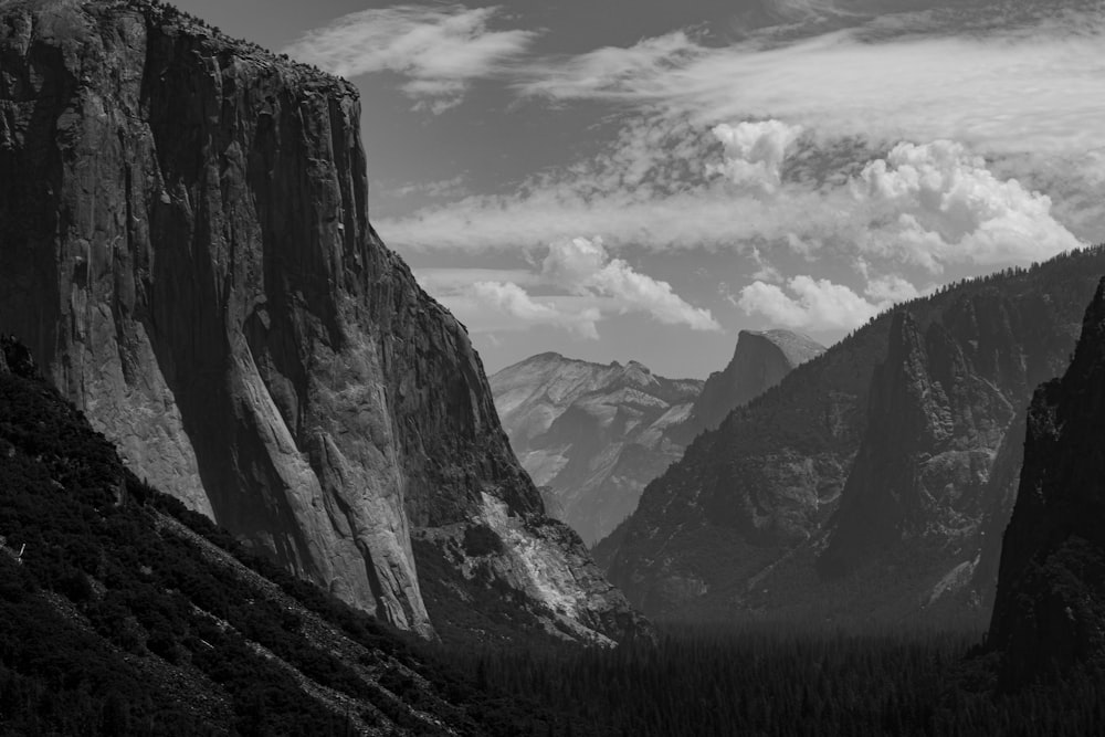 a black and white photo of mountains and clouds