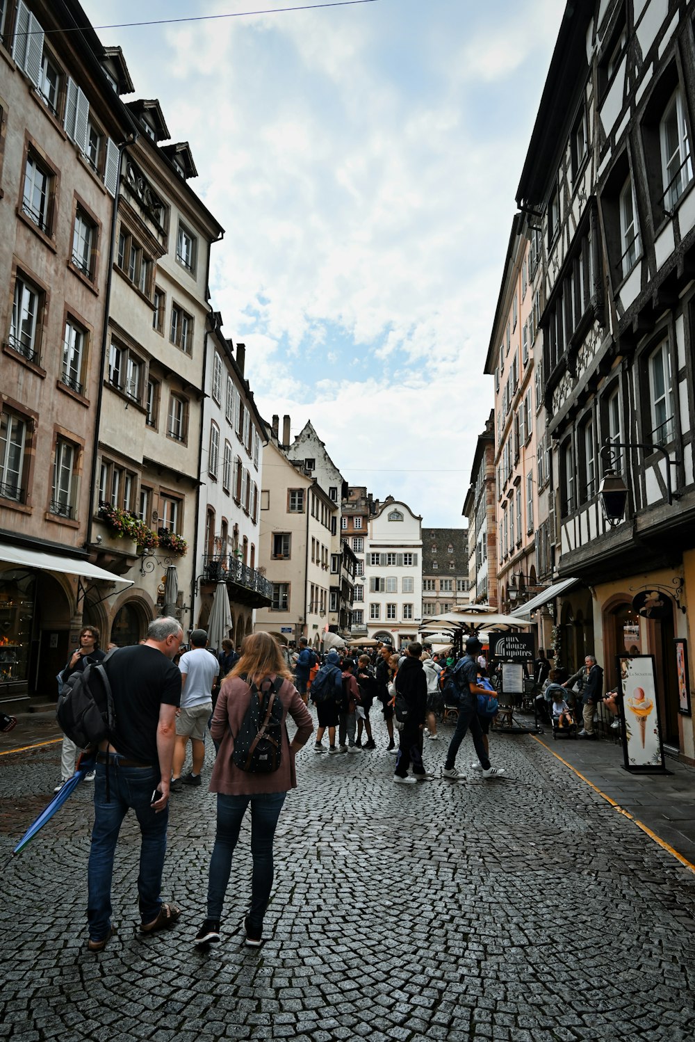 a group of people walking down a cobblestone street