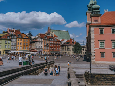 A local guide showing mission travelers a historic church in a bustling town square.
