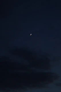 A serene night sky with delicate golden constellations and a crescent moon glowing softly.