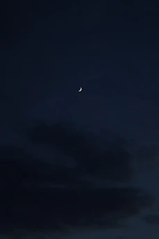 A serene night sky with delicate golden constellations and a crescent moon glowing softly.