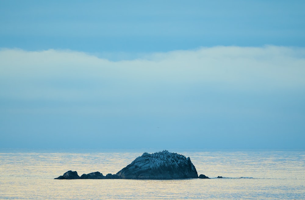 a large rock in the middle of the ocean