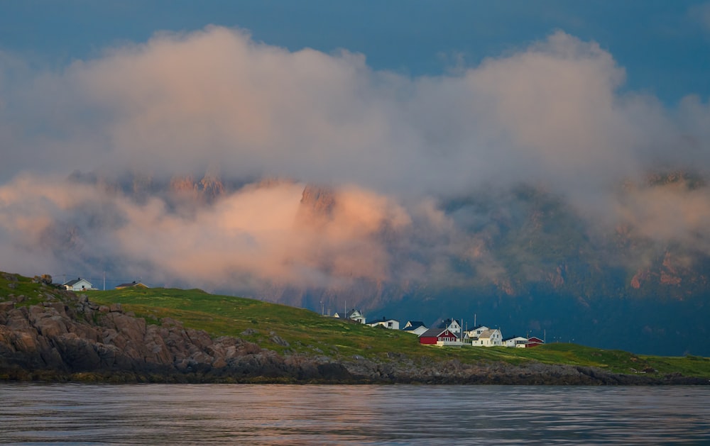 a hill with houses on top of it under a cloudy sky