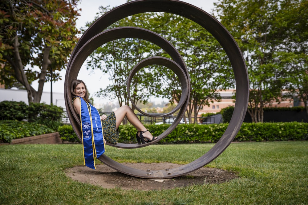 a woman sitting on top of a metal sculpture