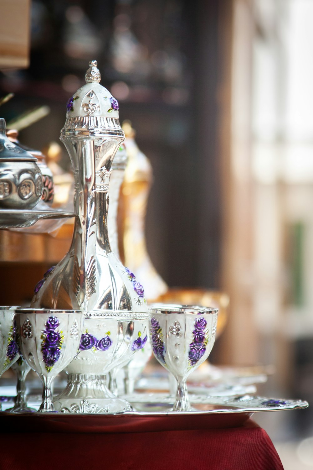 a table topped with lots of dishes covered in purple flowers