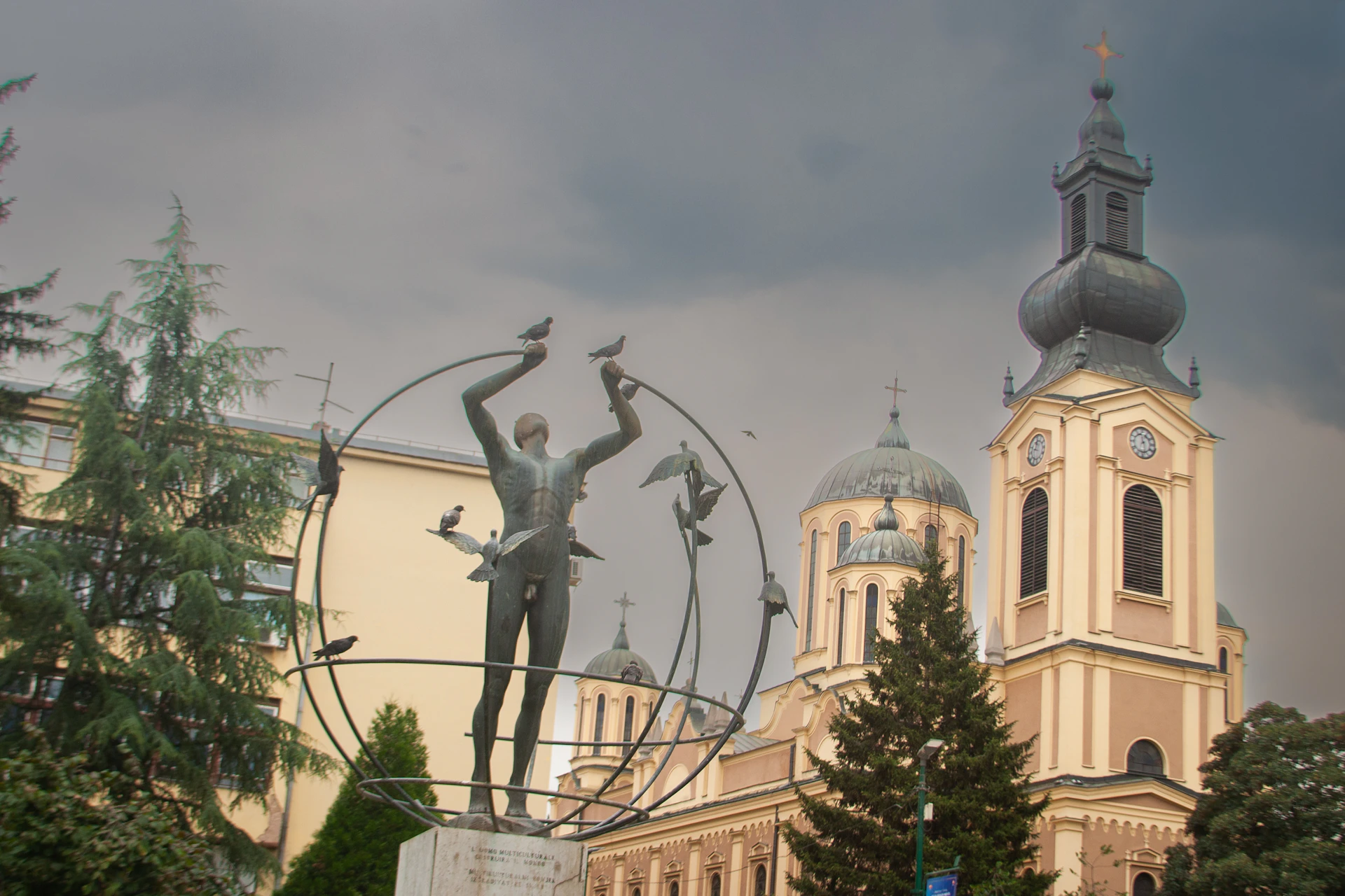 a statue in front of a building with a clock tower