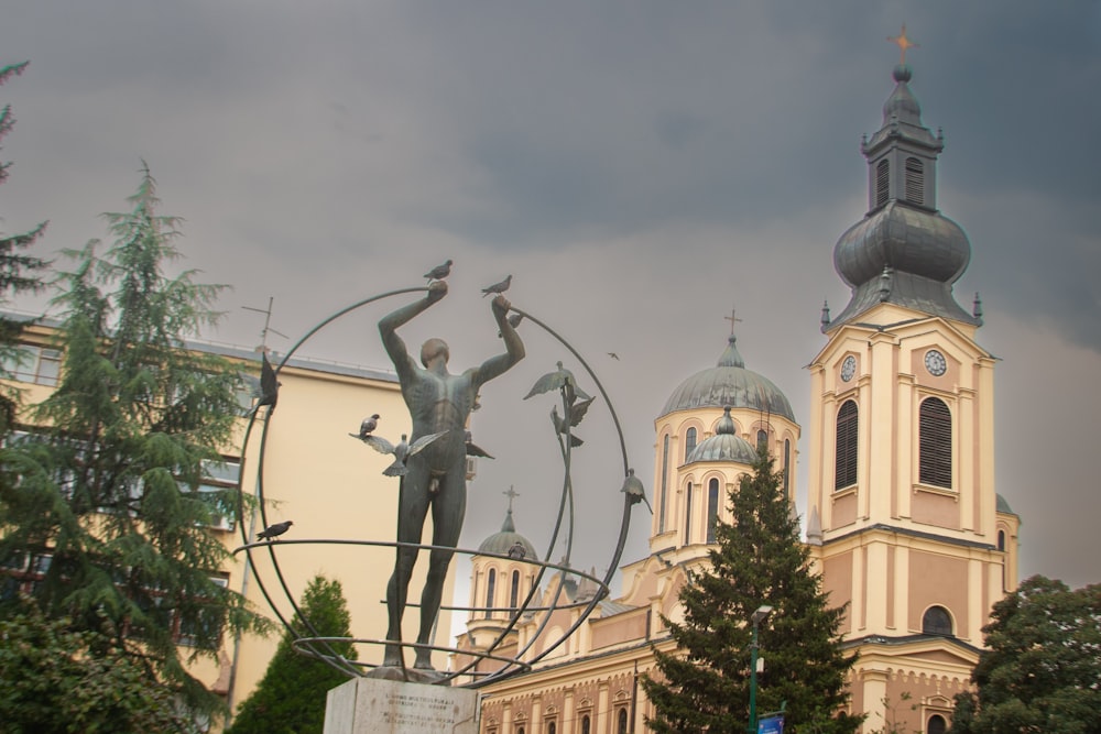 a statue in front of a building with a clock tower