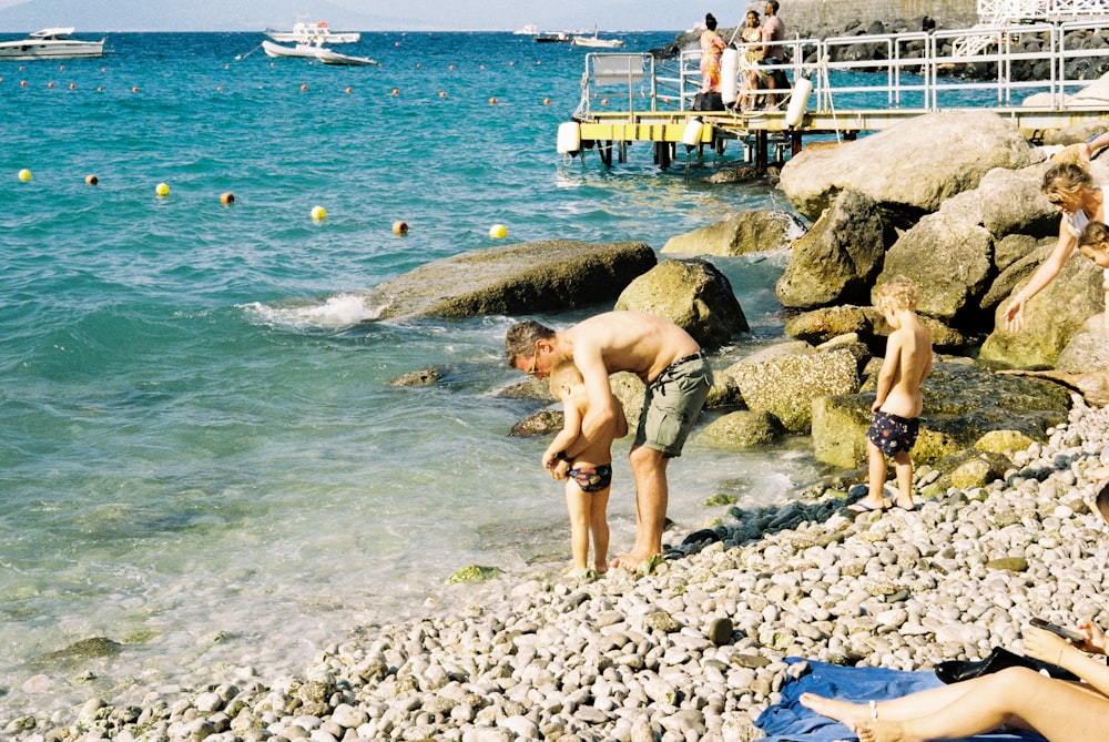 a group of people standing on top of a rocky beach