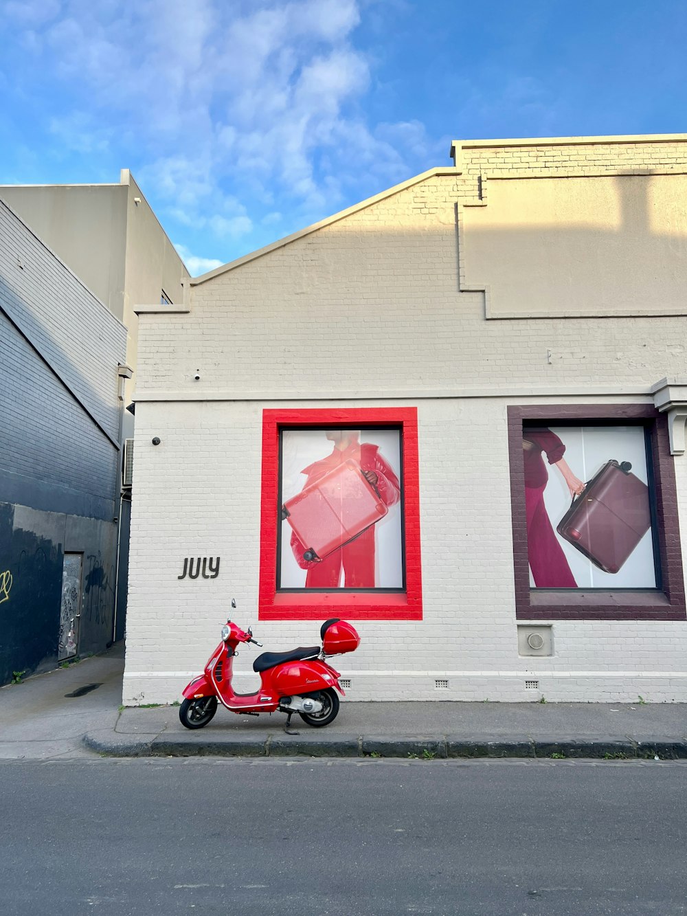 a red scooter parked in front of a building