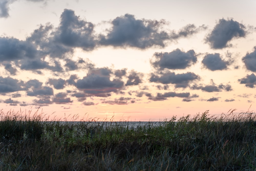 Die Sonne geht über dem Ozean unter, mit Wolken am Himmel