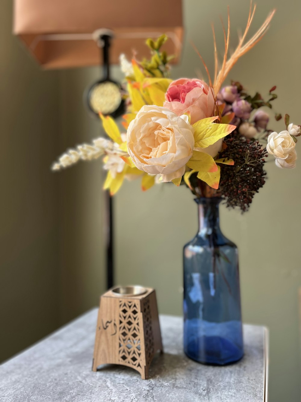 a blue vase with flowers on a table