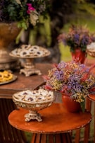 Close-up of a buffet table adorned with pink and green floral arrangements and artisanal dishes in earthy ceramic plates.