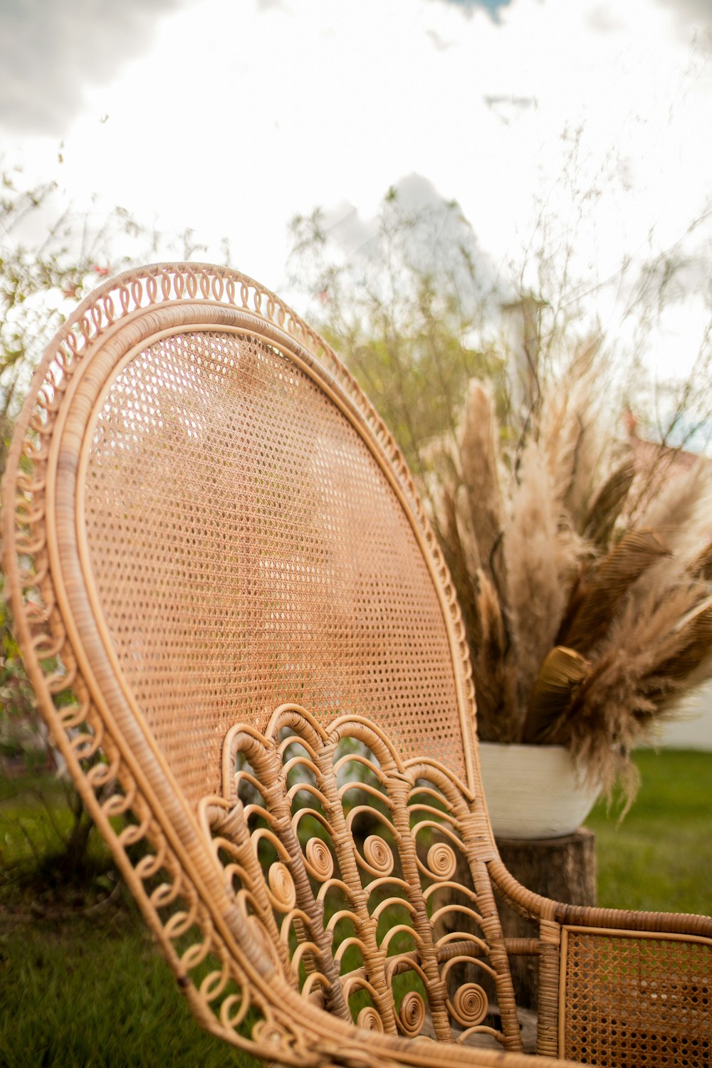 a wicker chair sitting on top of a lush green field