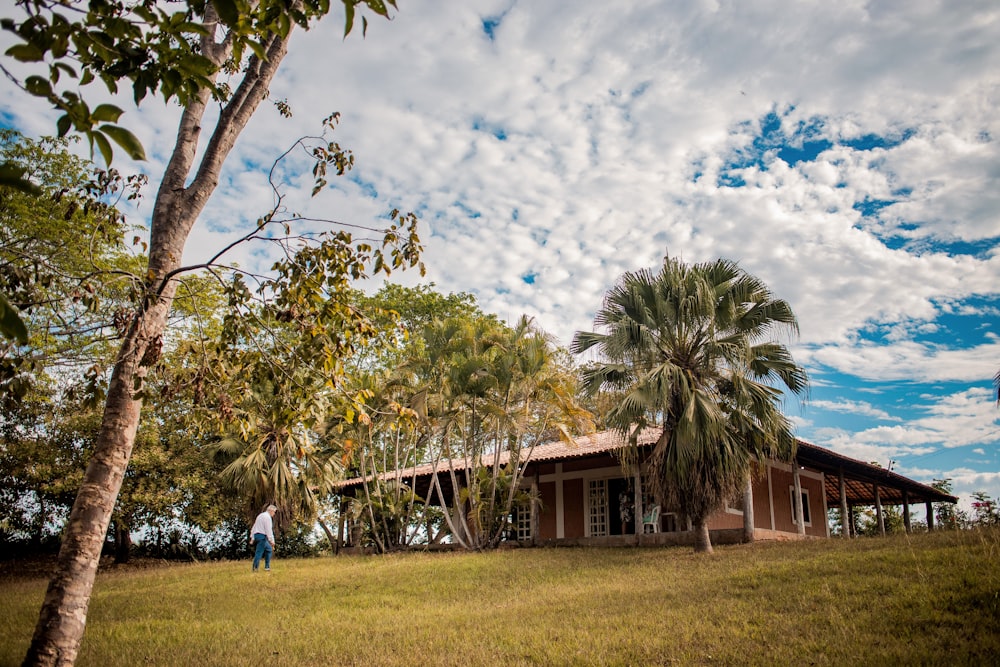 a person standing in front of a house on a hill