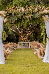 A softly lit outdoor wedding ceremony framed by delicate eucalyptus garlands and sage green accents.