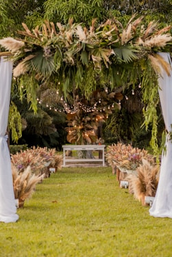 an outdoor wedding ceremony with white drapes and flowers