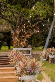 Outdoor event setup with rustic decorations surrounded by lush greenery and sunset hues.