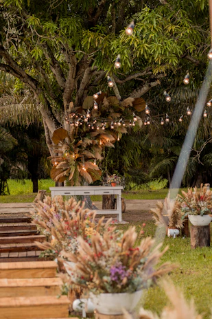 A cozy outdoor garden setup with rustic wooden tables and blooming flowers for a wedding event.